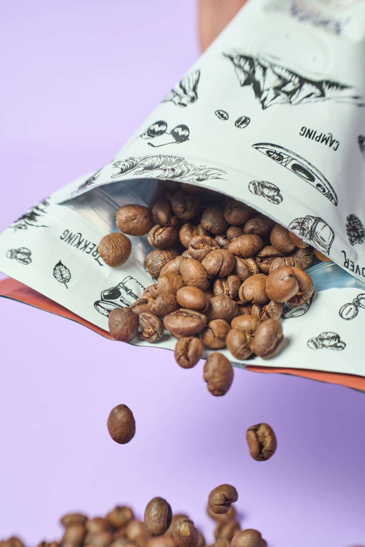Granos de café tostados cayendo de una bolsa de lona